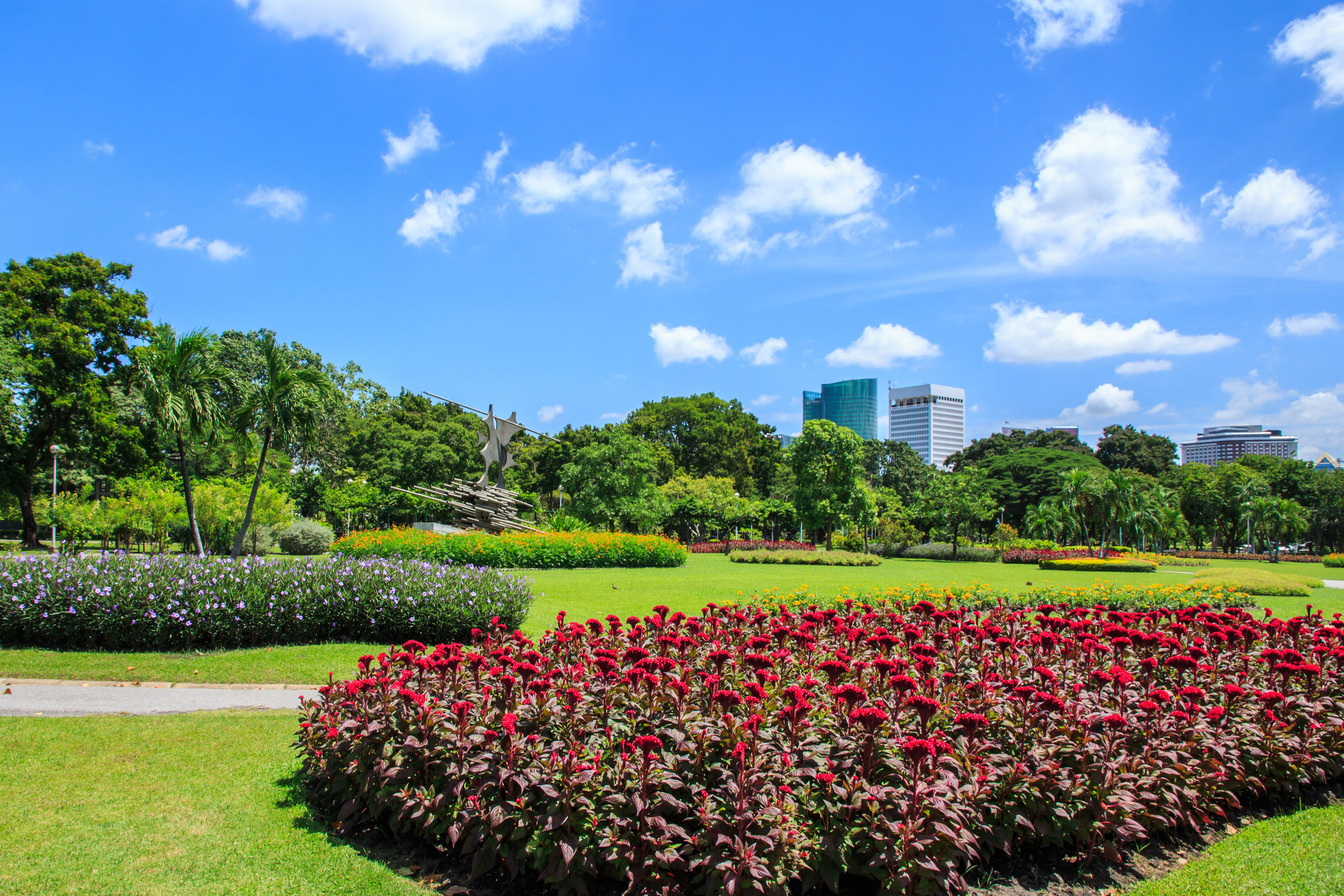 Parc luxuriant avec parterres de fleurs colorées et vue sur la ville