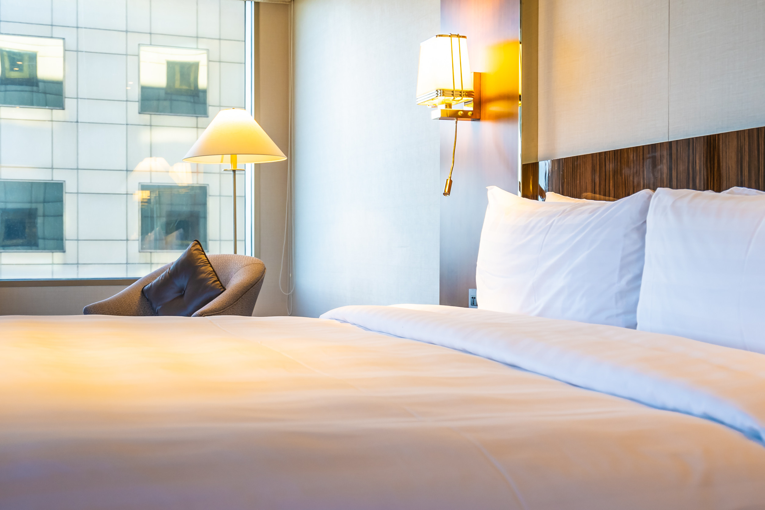 Chambre d'hôtel élégante avec lit confortable et vue sur la ville.