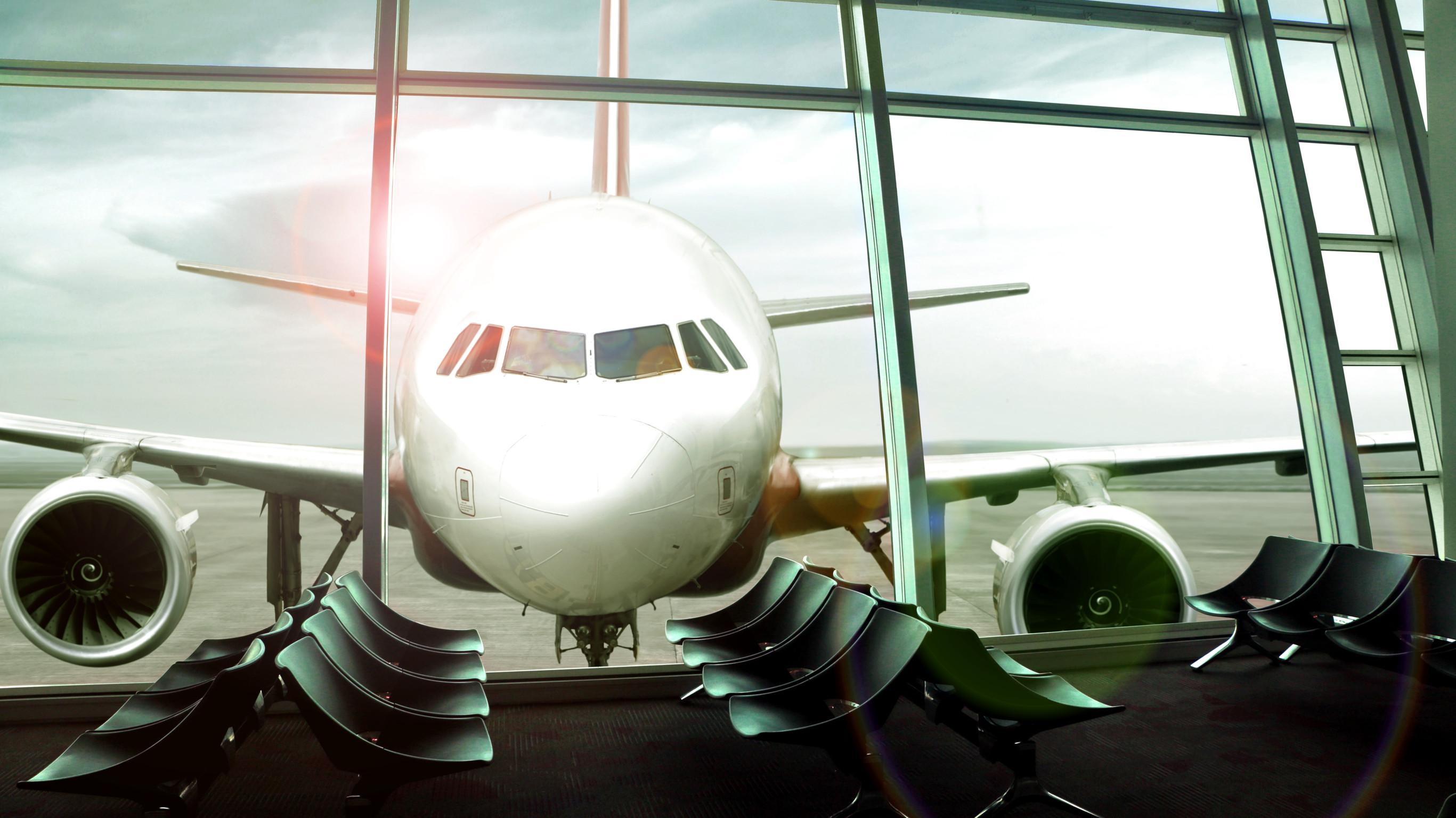 Airplane parked at gate viewed from empty airport waiting area