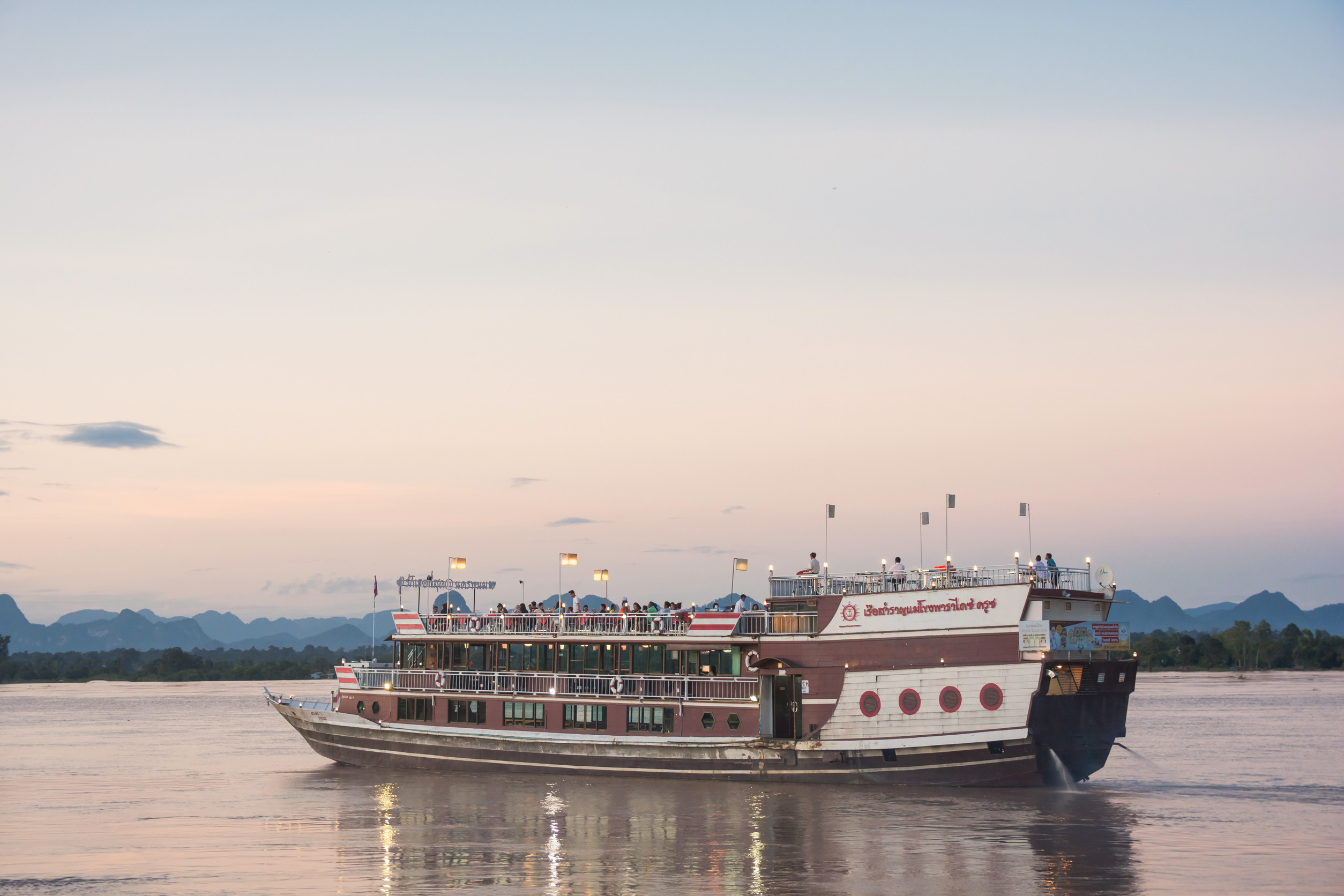 A large boat on a river at sunset