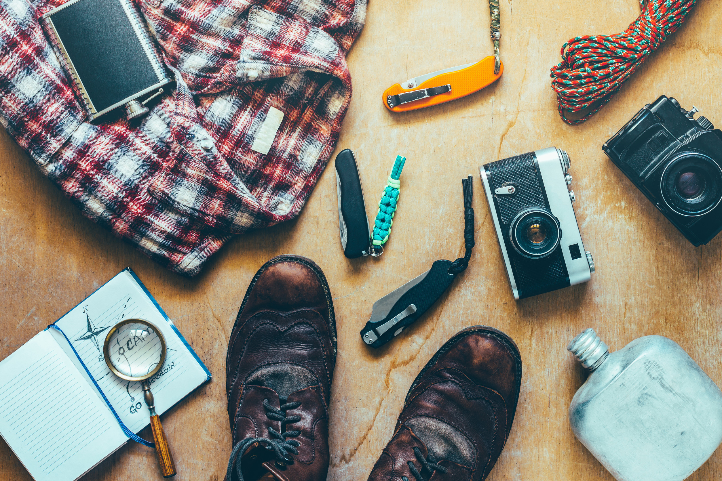 Travel and adventure essentials including boots, cameras, and survival gear