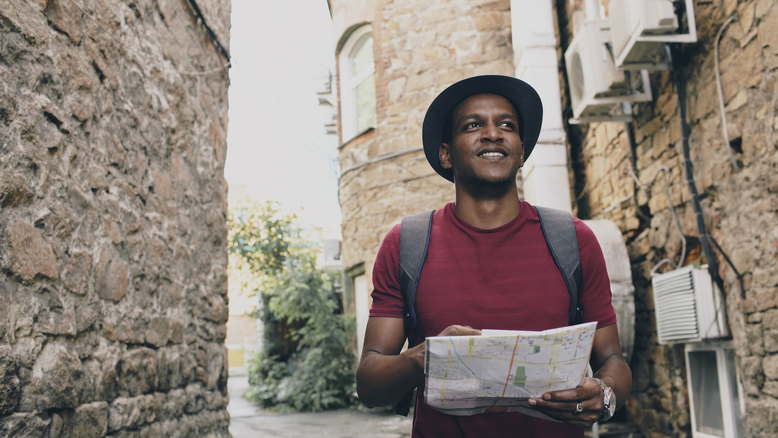 Afrikanischer Tourist sucht auf dem Stadtplan nach Wegbeschreibungen